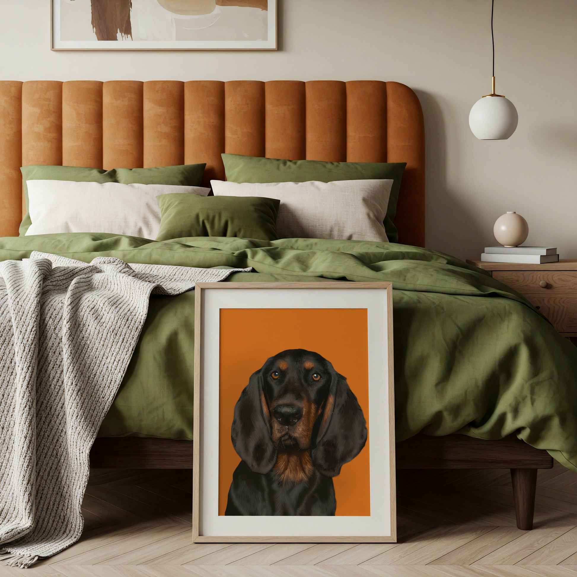 Framed artwork of a coonhound dog on a bed with green bedding and an orange headboard.