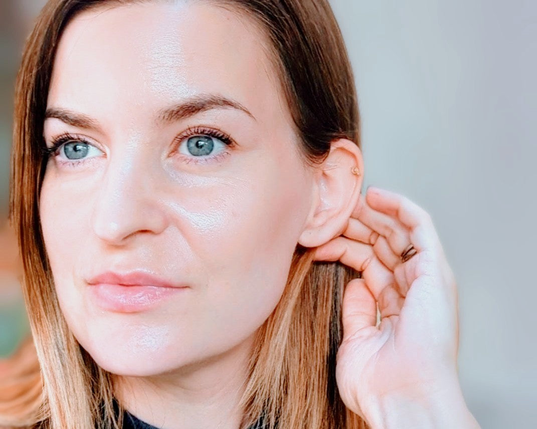 Joy adjusting an earring with a blurred background